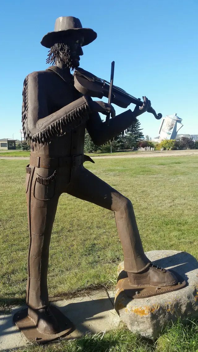 Fiddler sculpture with the giant coffee pot behind